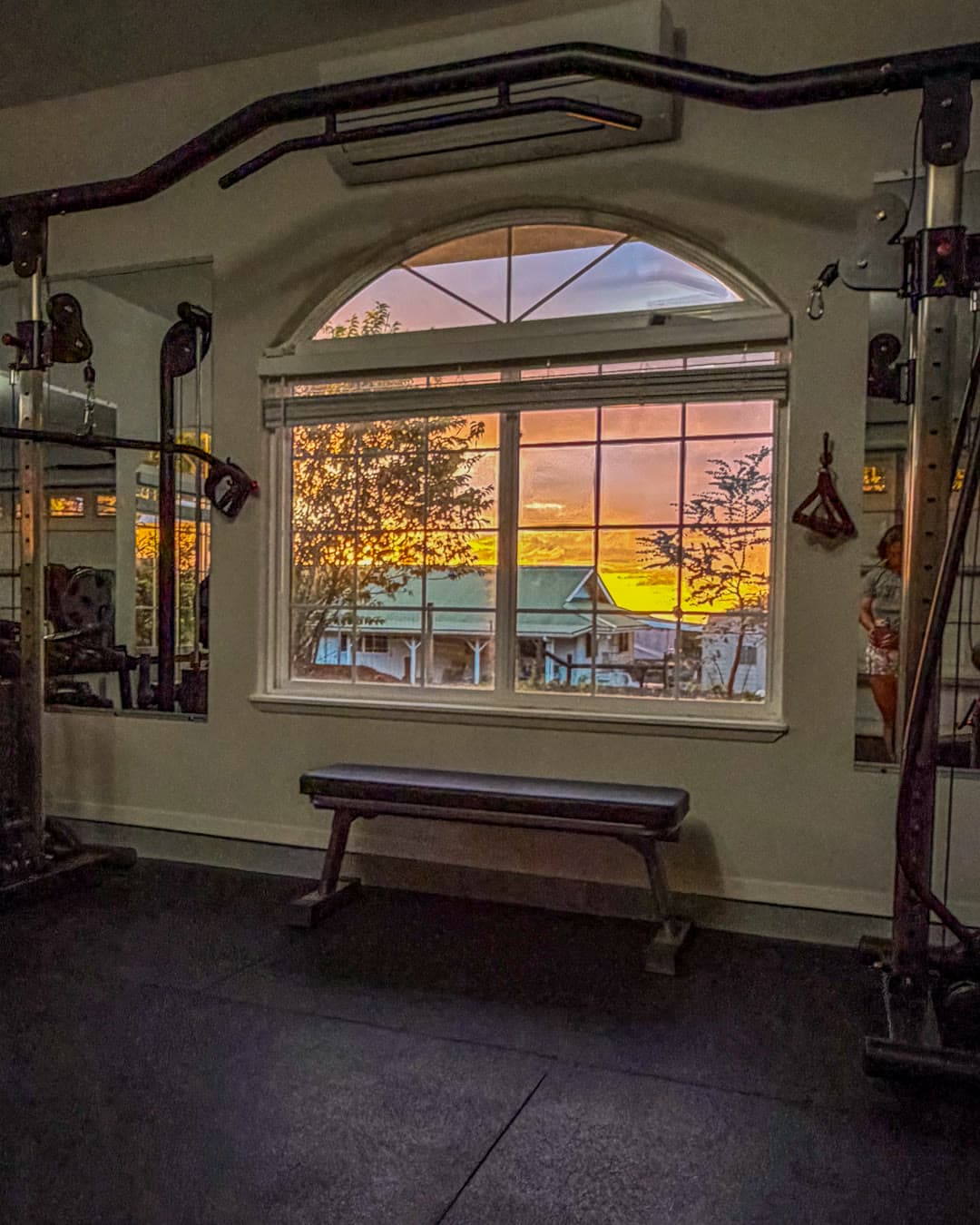 Light through the arched studio window over a bench in Hilo.
